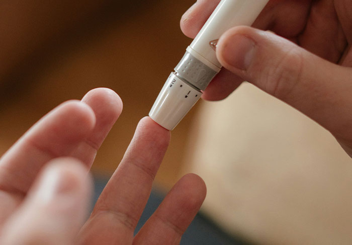 Woman checking blood sugar with a device, illustrating concerns about diabetic health during unexpected walking trips.
