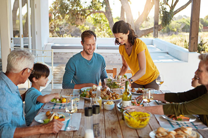 Family enjoying outdoor meal together, highlighting tension as man calls daughter-in-law fat while others react.