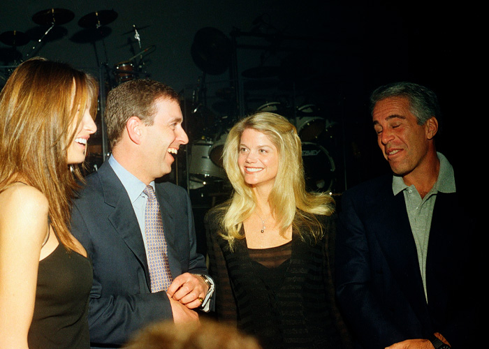 Prince Andrew and Jeffrey Epstein smiling and socializing with two women at a dimly lit event.