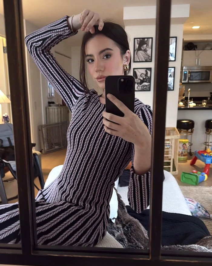 Young woman taking a mirror selfie indoors, reflecting on Elon Musk&rsquo;s dramatic announcement about 13th child with influencer.