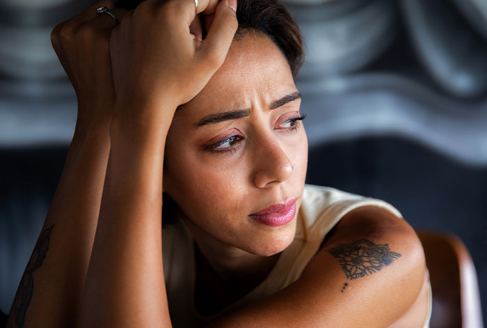 Woman looking distressed indoors, struggling with emotions related to ex’s dog and shelter threats. Woman looking distressed indoors, struggling with emotions related to ex’s dog and shelter threats.