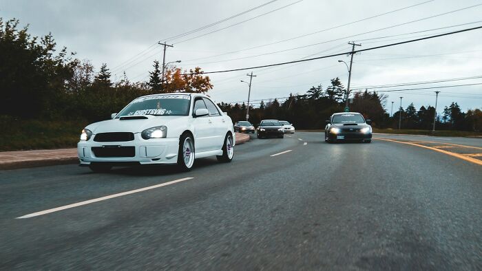 A group of cars driving on a road during overcast weather, illustrating common daily dangers on the streets.
