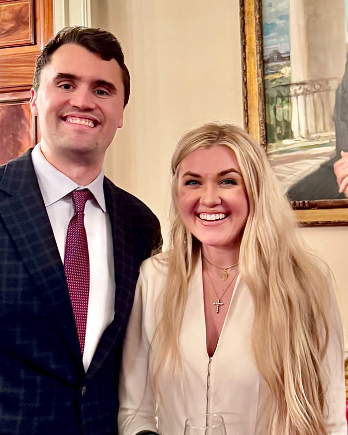 Erika Kirk smiling with a man indoors, showing her makeup transformation before Charlie's assassination.