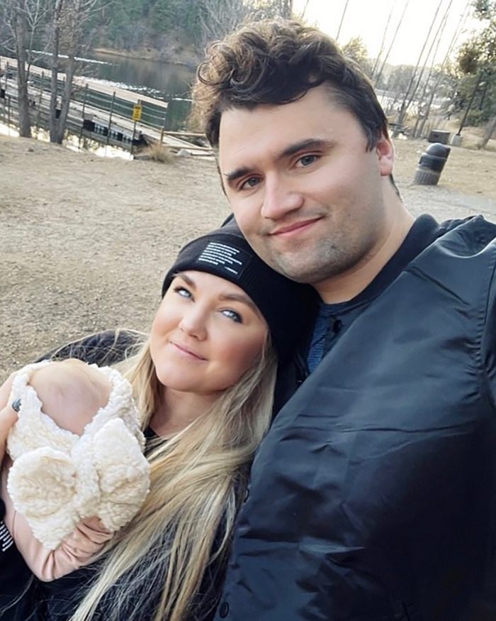 Erika Kirk outdoors with a man and baby, showing a natural makeup look before Charlie's assassination.