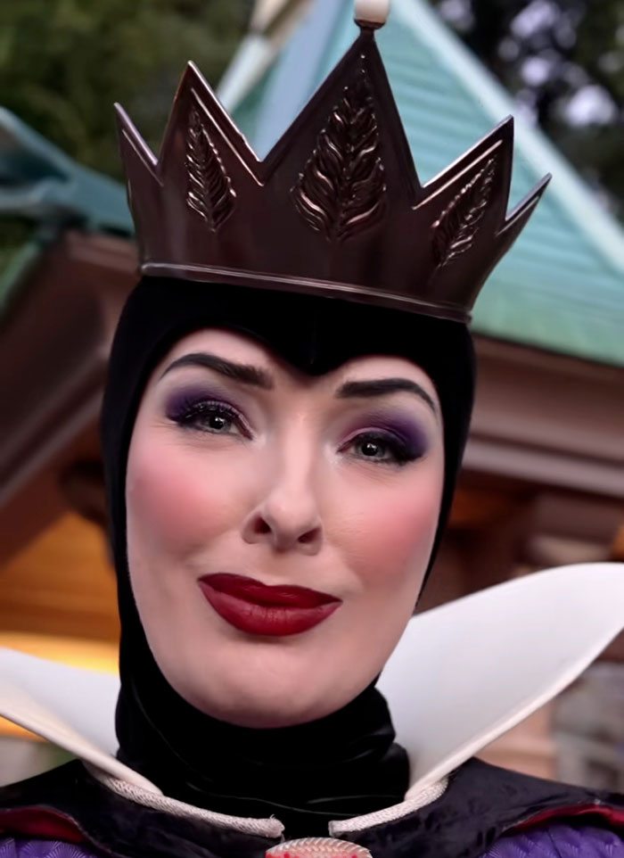 Close-up of viral Evil Queen in costume with crown and dramatic makeup at Disneyland revealing her identity after being fired.