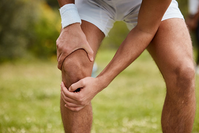 Person holding knee in pain during outdoor sports injury, highlighting times experts were wrong about treatment.