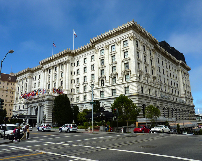 Historic multi-story building with flags outside, city street, and pedestrians, illustrating mystery deepens surrounding Victoria's passing.