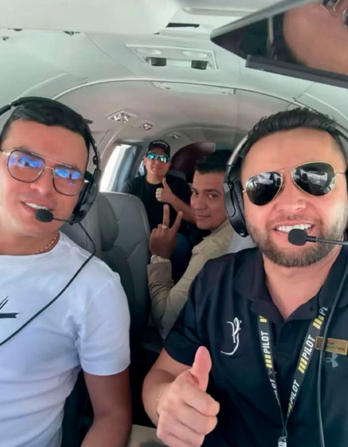 Four men inside a small plane wearing pilot headsets, two giving thumbs up, relating to famous singer plane crash. Four men inside a small plane wearing pilot headsets, two giving thumbs up, relating to famous singer plane crash.