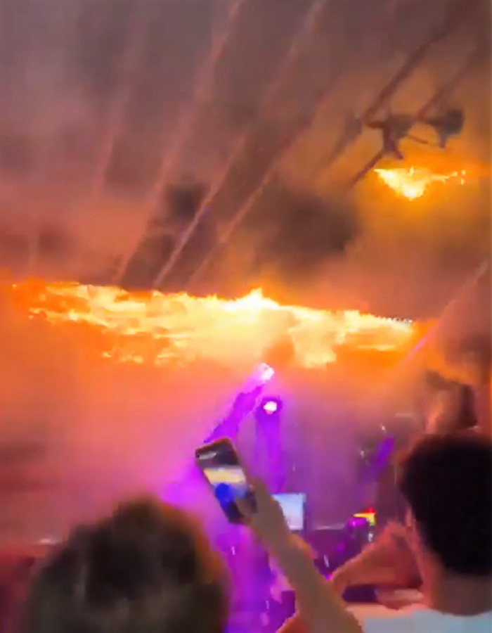 Fire engulfing ceiling at Swiss ski resort with people capturing the blaze, related to waitress allegedly starting deadly fire.
