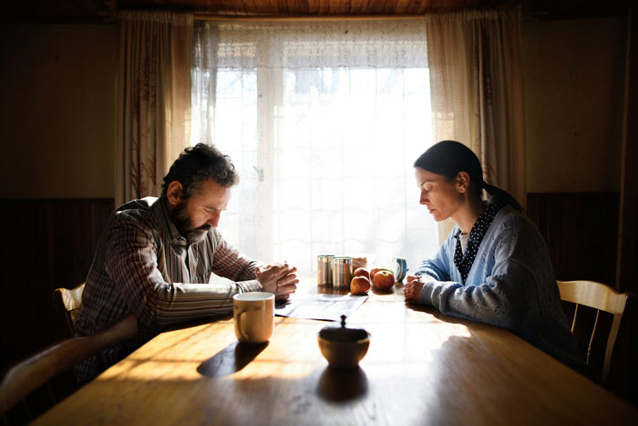 Man and woman sitting silently at a kitchen table, reflecting on family struggles and children viewed as failures by their dad. Man and woman sitting silently at a kitchen table, reflecting on family struggles and children viewed as failures by their dad.