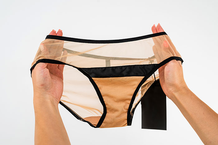 Hands holding sheer women's underwear, highlighting body awareness and women's health insights.