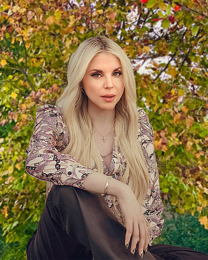 Firerose posing outdoors with long blonde hair, wearing a patterned blouse, relating to bombshell audio accusations against Billy Ray Cyrus.