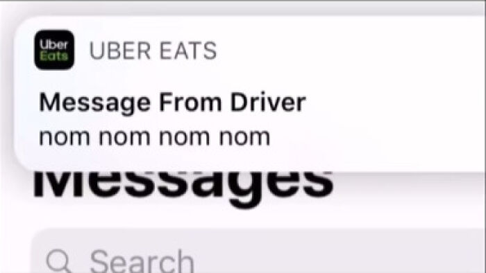 Notification from Uber Eats driver with a funny message reading nom nom nom nom in a text alert.