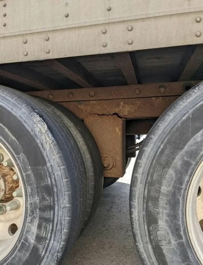Woke up expecting - rusted c*****d trailer axle bracket visible between two worn truck tires