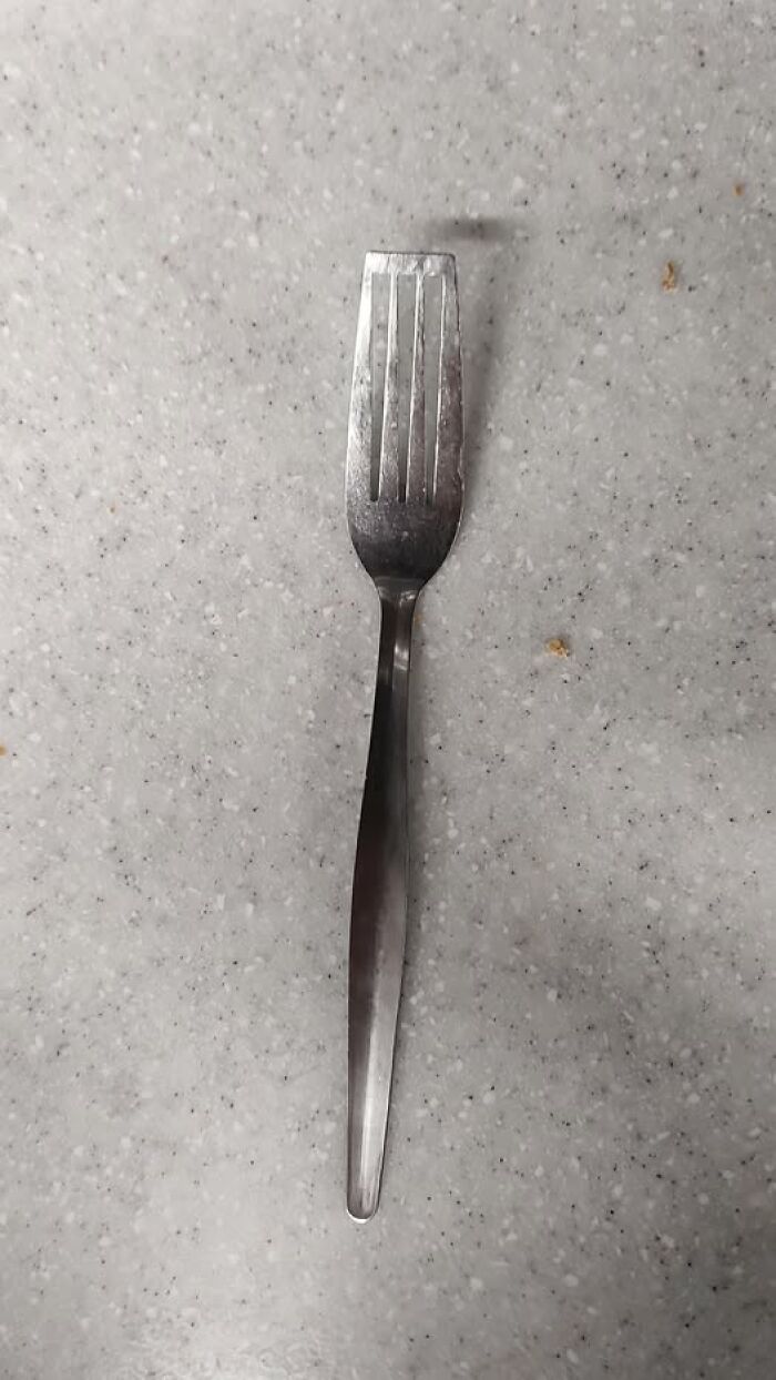 Woke Up Expecting stainless steel fork with flattened tines on speckled countertop