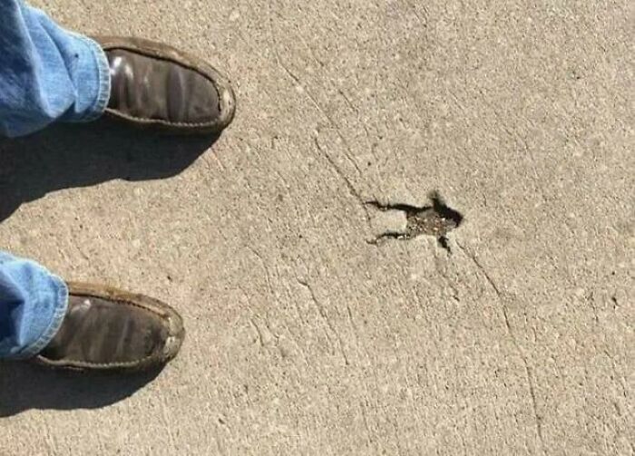 Woke up expecting a normal day: brown shoes and jeans on sidewalk beside crack shaped like tiny human figure