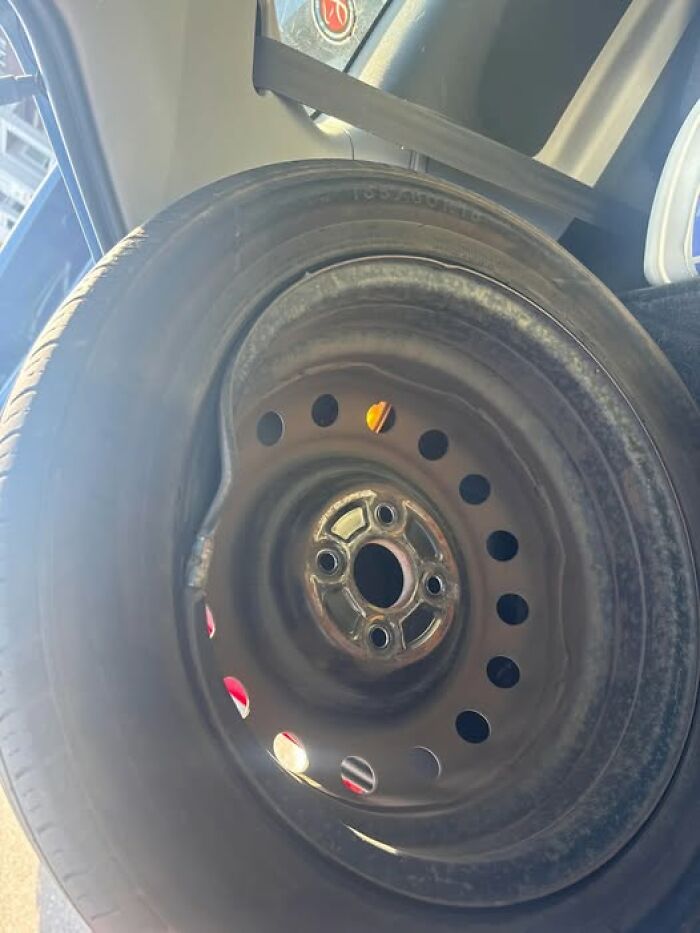 Bent spare tire steel wheel in car trunk, woke up expecting a normal day