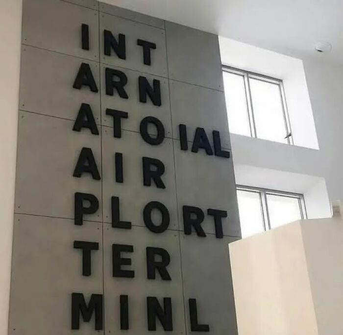 Jumbled letters on a wall creating a confusing phrase about an international airport terminal.