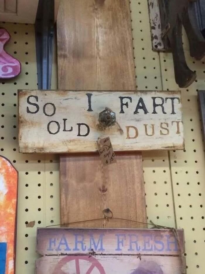 Rustic wooden sign with confusing text displaying So I fart old dust, a brain-breaking reading puzzle.