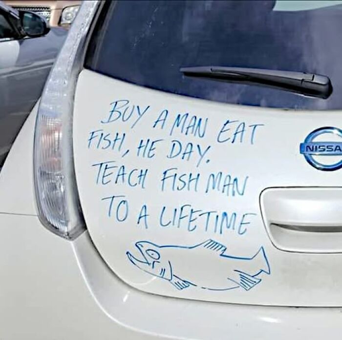 Funny car rear message with confusing text about fish and a hand-drawn fish, illustrating brain-breaking reading moments.