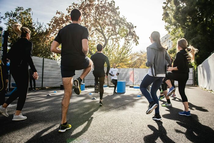 Group of people exercising outdoors in sunlight, highlighting daily dangers you might not realize you’re exposing yourself to.