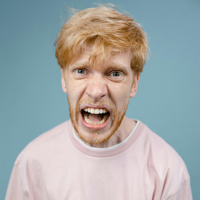 Young man with red hair showing anger in a pink shirt, representing the male Karen Gen Z has named. Young man with red hair showing anger in a pink shirt, representing the male Karen Gen Z has named.