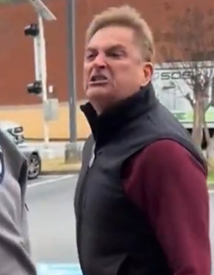 Angry man resembling male version of Karen during a public meltdown on a city street with blurred background.