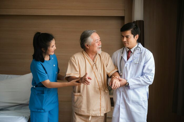 Elderly patient with really bad prognosis supported by doctor and nurse in a medical setting showing hope and recovery