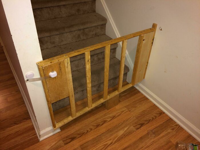 Unstable DIY wooden stair gate poorly constructed and failing to provide safety, illustrating humorous DIY fails.