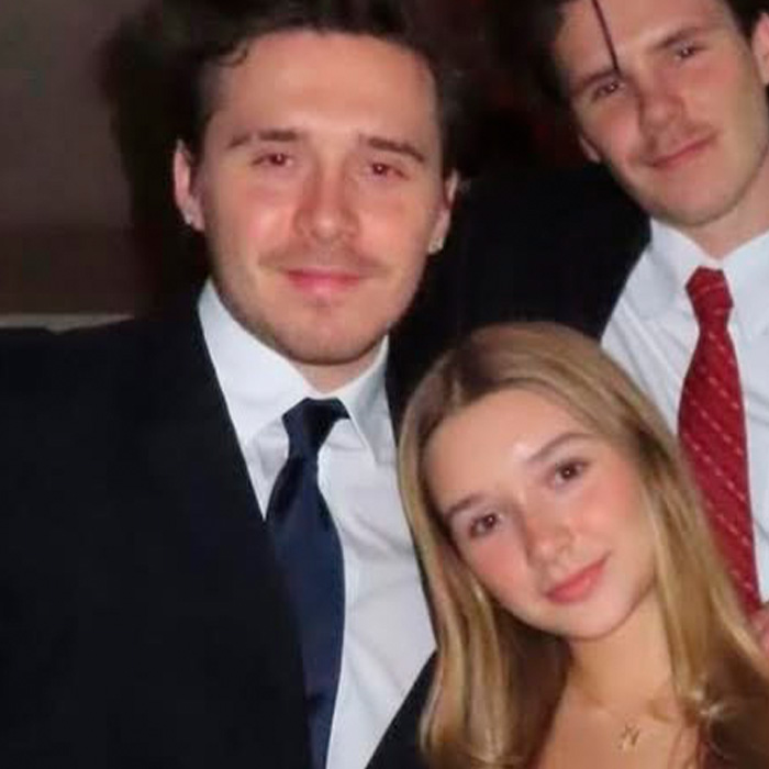 Harper Beckham with two men, dressed formally, posing closely in a dimly lit setting following Brooklyn&rsquo;s family incident.