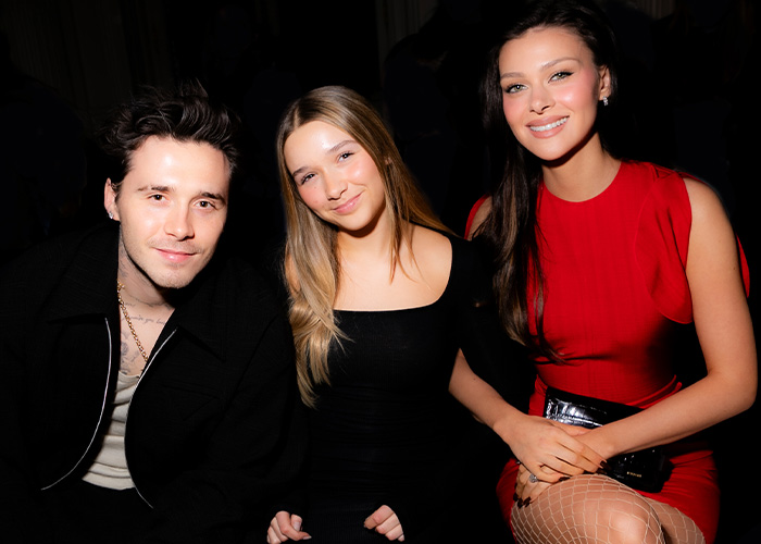 Harper Beckham pictured smiling with two companions at a formal event, breaking silence after Brooklyn&rsquo;s attack on parents.