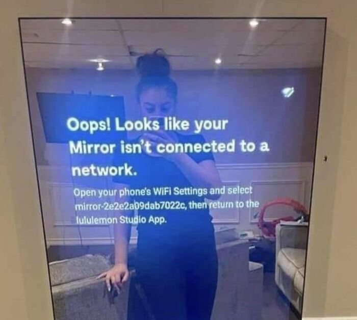 Smart mirror displays network error message with a woman’s reflection, highlighting themes of living in a digital dystopia.