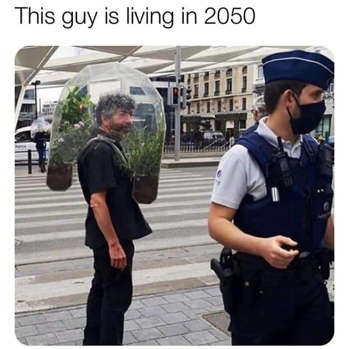 Man wearing a backpack terrarium walking on city street near police officer, illustrating dystopia in daily life.