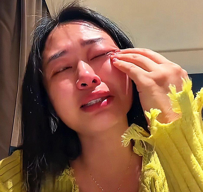 Woman crying and wiping tears after husband violently trashes home over $215 dishwasher purchase without telling him