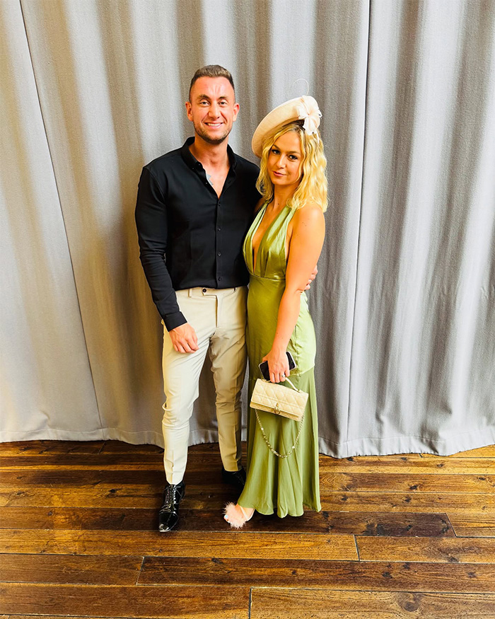 Husband and wife dressed elegantly, posing together indoors before tragic loss on first anniversary.