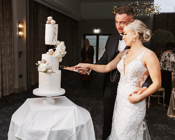 Husband and wife cutting wedding cake together, capturing the heartbroken husband after wife&rsquo;s tragic loss on anniversary.