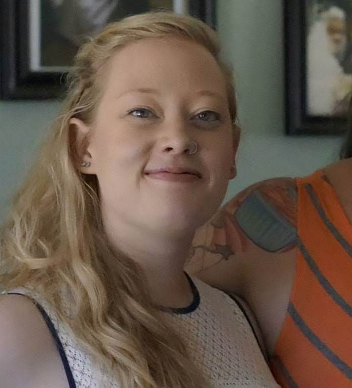 Woman with long blonde hair and nose ring smiling in a casual indoor setting related to ICE agent fundraiser controversy