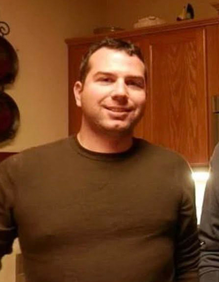 Man smiling indoors wearing a brown shirt, related to outrage as ICE agent involved in online fundraisers controversy.