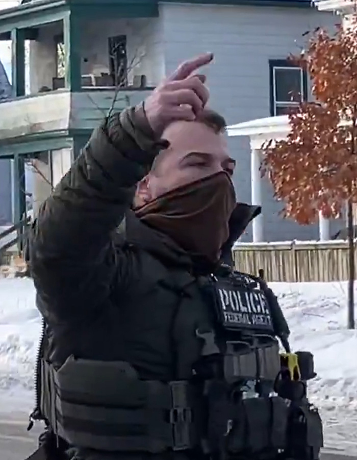 ICE agent wearing tactical gear and mask outdoors near a house, linked to controversy and online fundraisers controversy