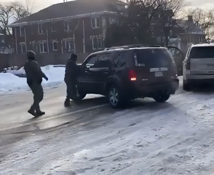 Law enforcement officers near a black SUV on a snowy street connected to woman slain by ICE in Minneapolis case.