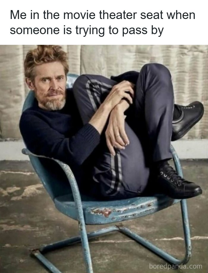 Man curled up awkwardly in a worn chair, captioned about movie theater seat, highlighting random memes to spice life up.