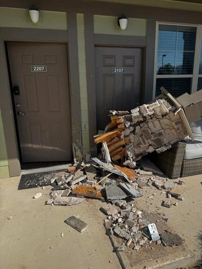 Broken wall debris scattered outside apartment doors illustrating unfortunate events and mishaps.