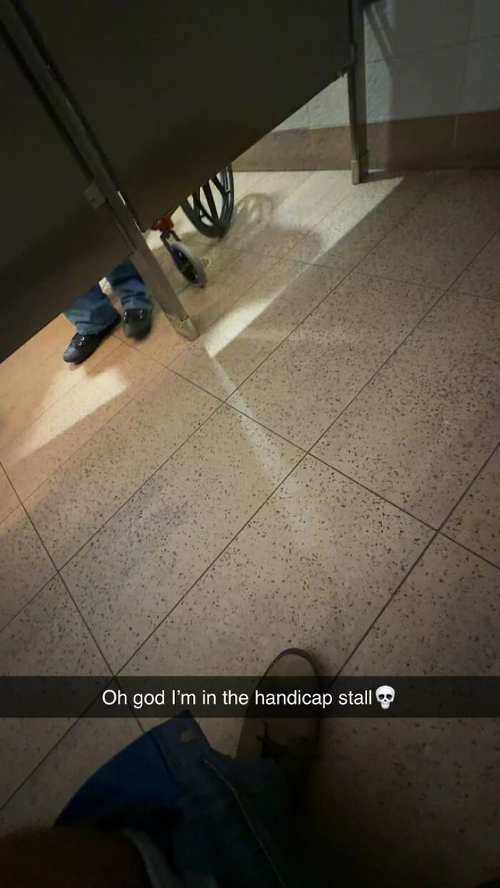 Person stuck in a handicap stall with a wheelchair visible nearby in an unfortunate event photo.