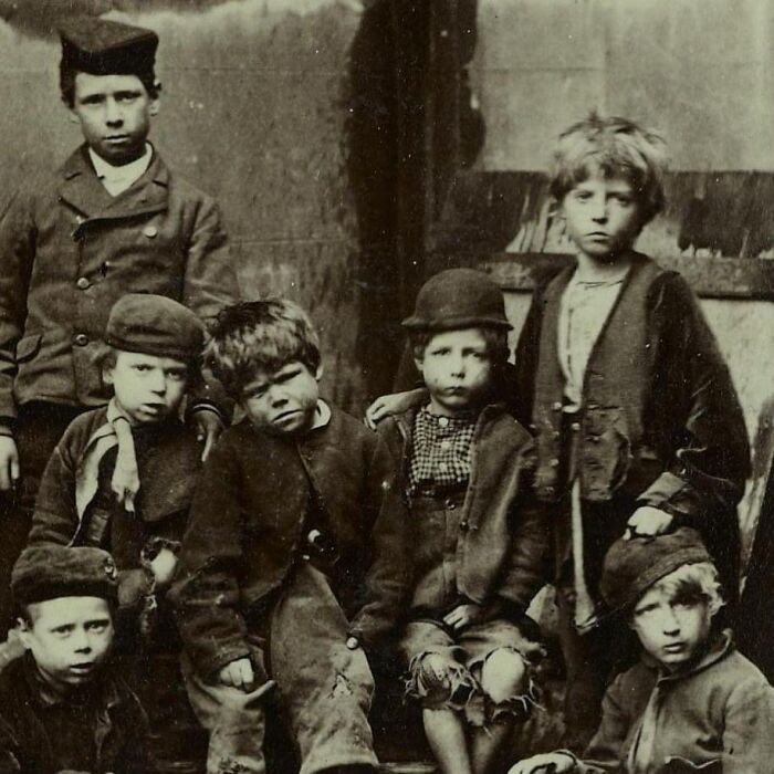 Group of poor, sad children in worn clothes, capturing the historic and emotional depths of humanity’s past.