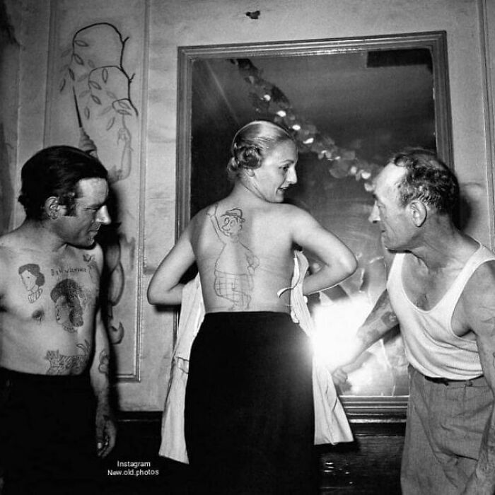 Black and white photo showing three people with tattoos, reflecting the sad, beautiful, and sometimes horrific history of humanity.