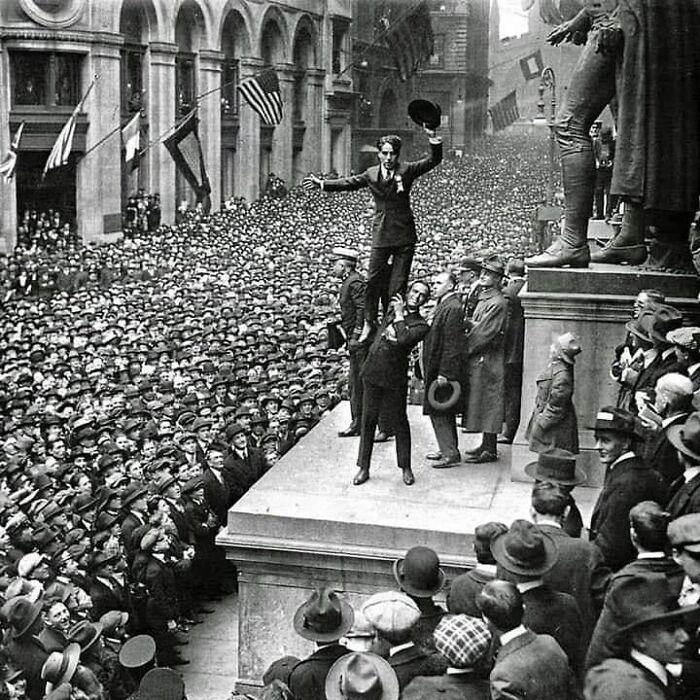 Black and white historic photograph showing a large crowd witnessing a public speech in early 20th century, highlighting humanity history.