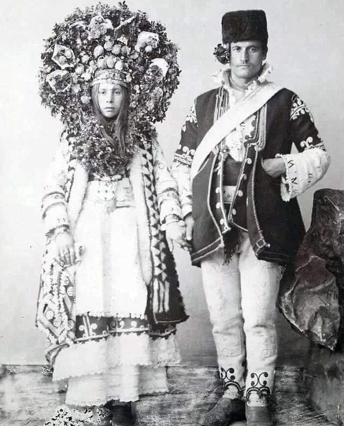 Black and white photograph of a couple in traditional clothing showcasing the history of humanity through cultural attire.