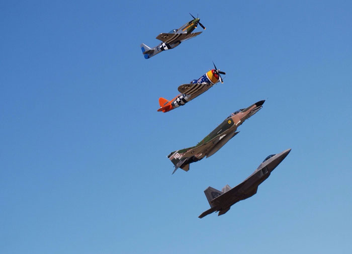 Four military aircraft in formation against a clear blue sky showing dramatic before and after designs.