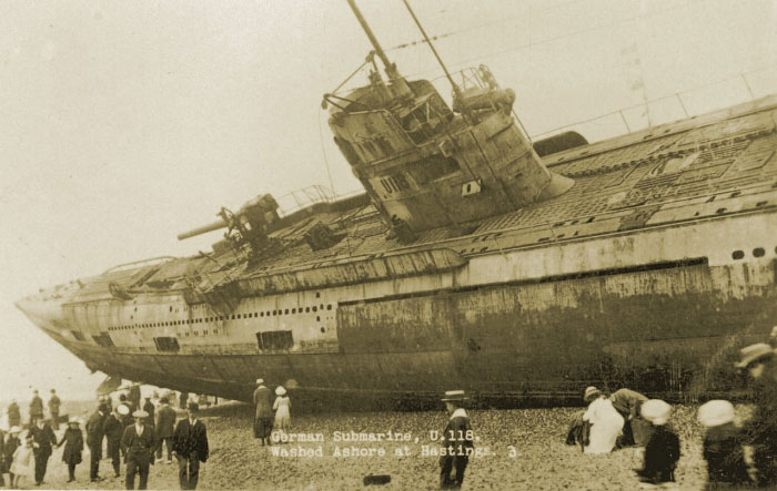 Vintage photo of a German submarine washed ashore with people gathered, showing a hidden side of history.