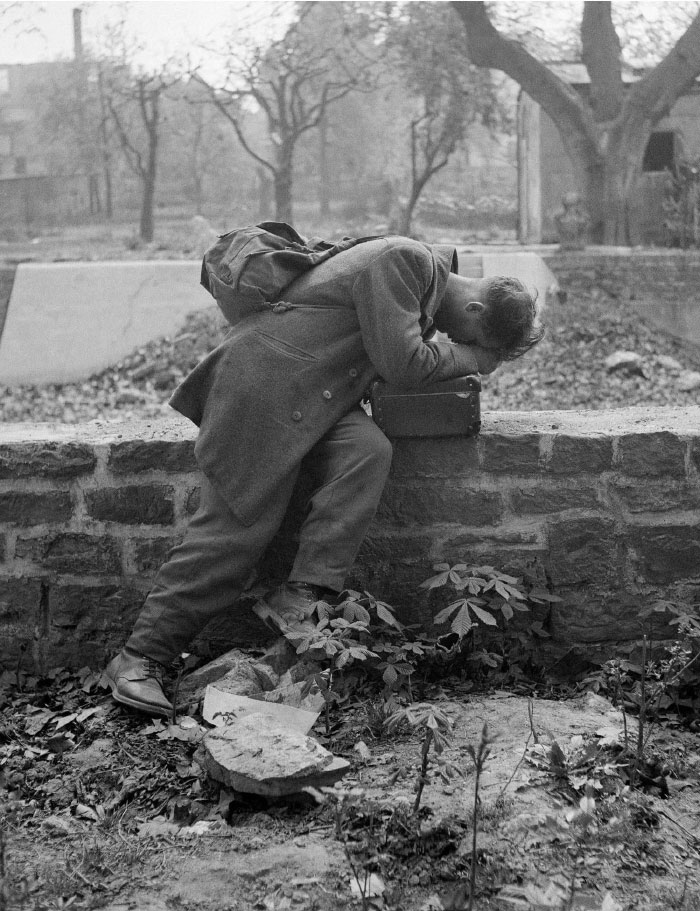 Young soldier resting head on a stone wall, showing a side of history rarely seen in historical textbooks.